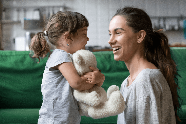 Child clutching a teddy bear and looking at an adult woman