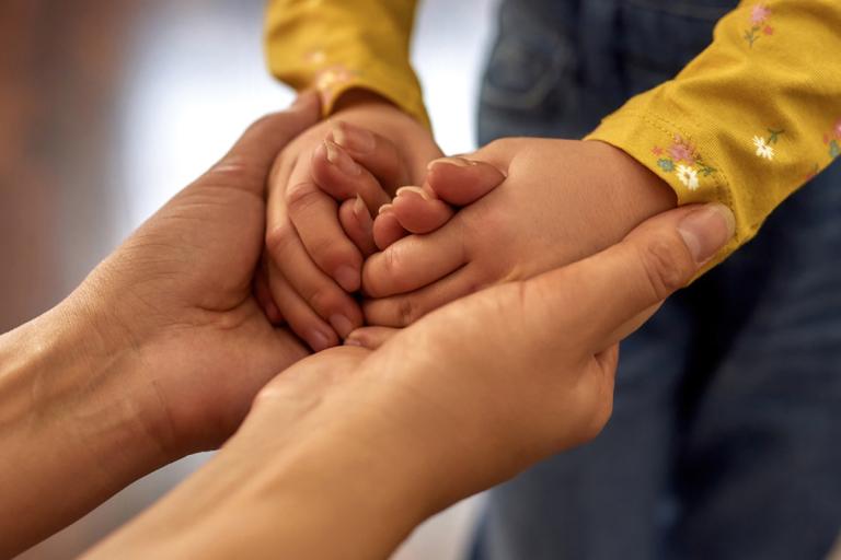 Adults hands cupping a child's hands