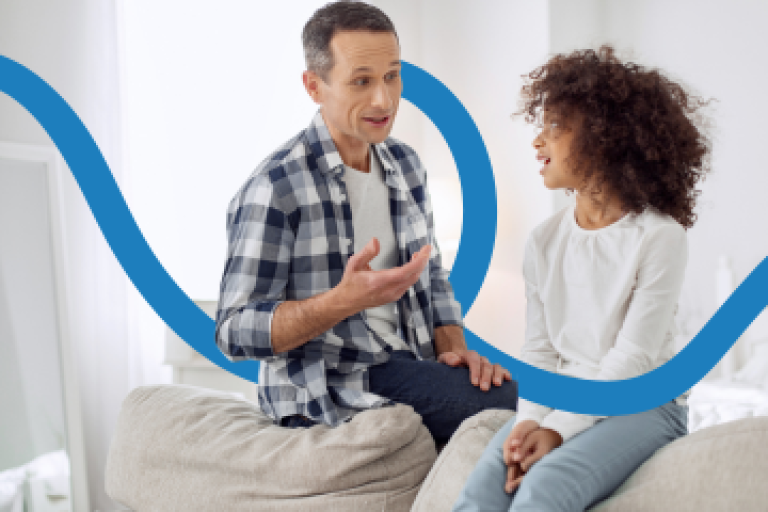 A male foster carer talks to a teenage girl.