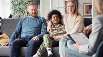 Two foster carers sitting either side of a child
