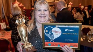 Janet holds her certificate and trophy