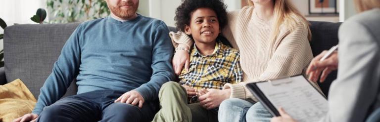 Two foster carers sitting either side of a child
