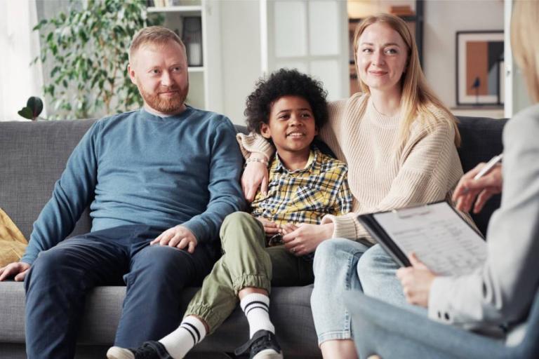 Two foster carers sitting either side of a child